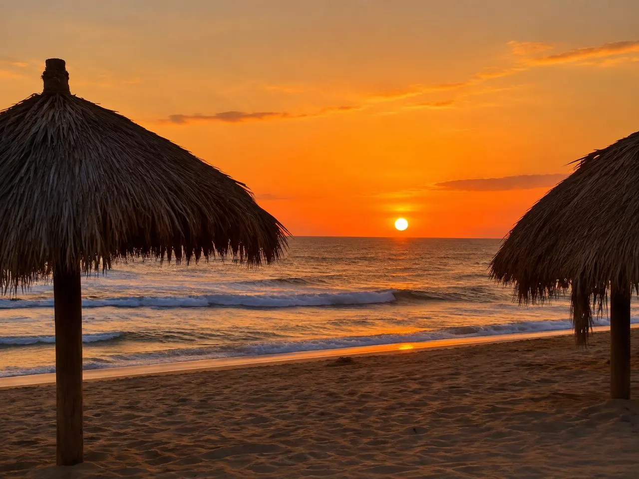 Sol sobre el mar abierto en Pie de la Cuesta entre palapas