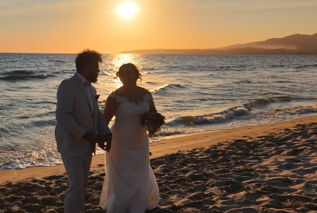 Pareja caminando en la playa al atardecer