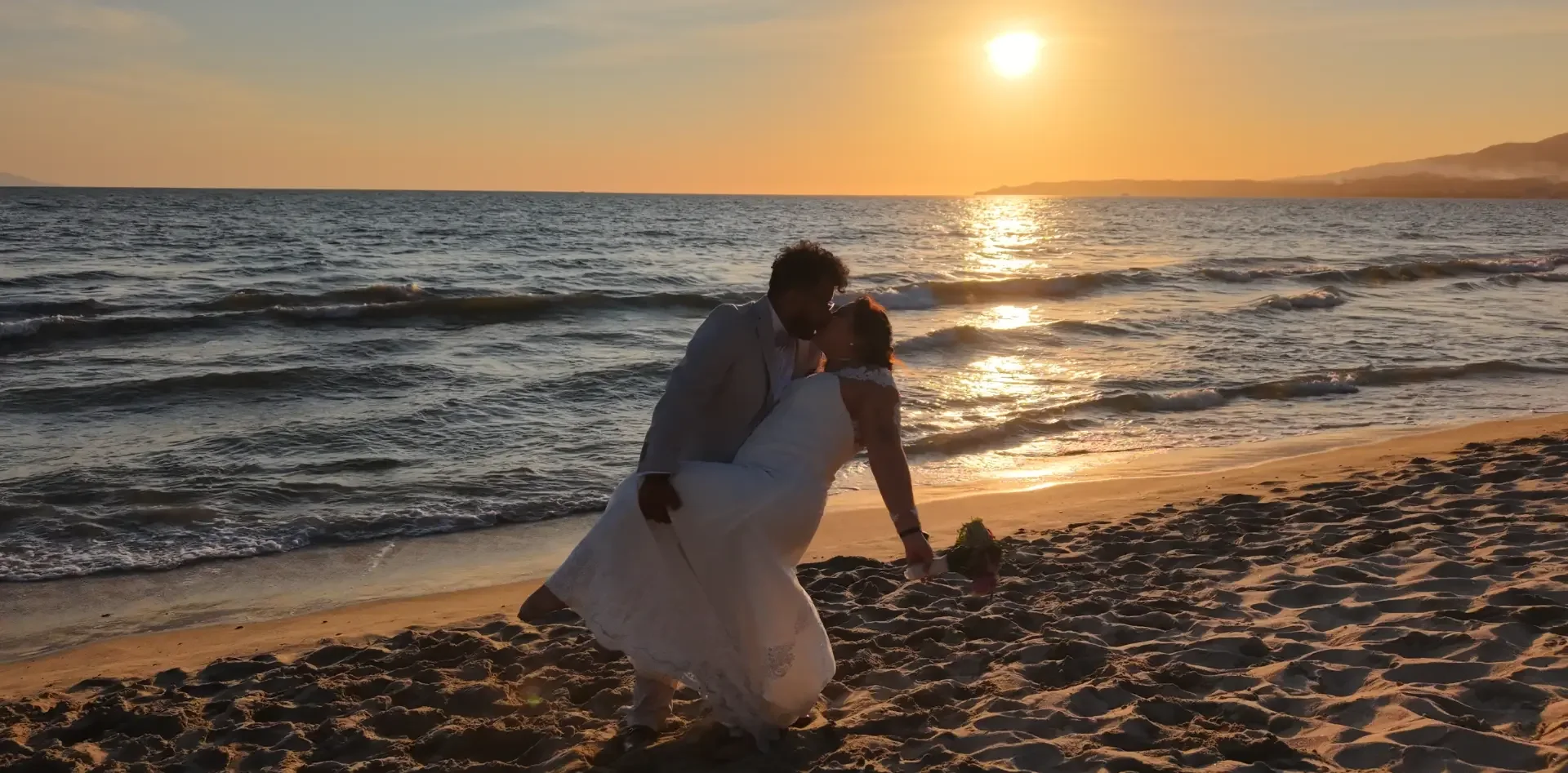 Pareja abrazada en la playa al atardecer