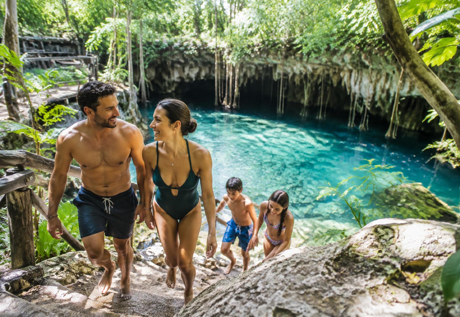 Familia explorando un cenote rodeado de selva en la Riviera Maya