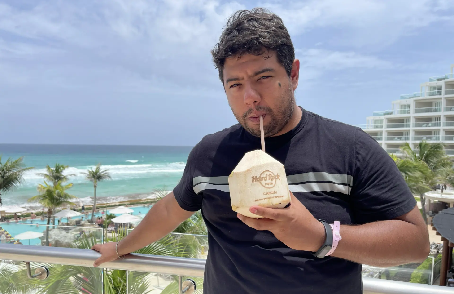 Viajero disfrutando una bebida en un resort de playa