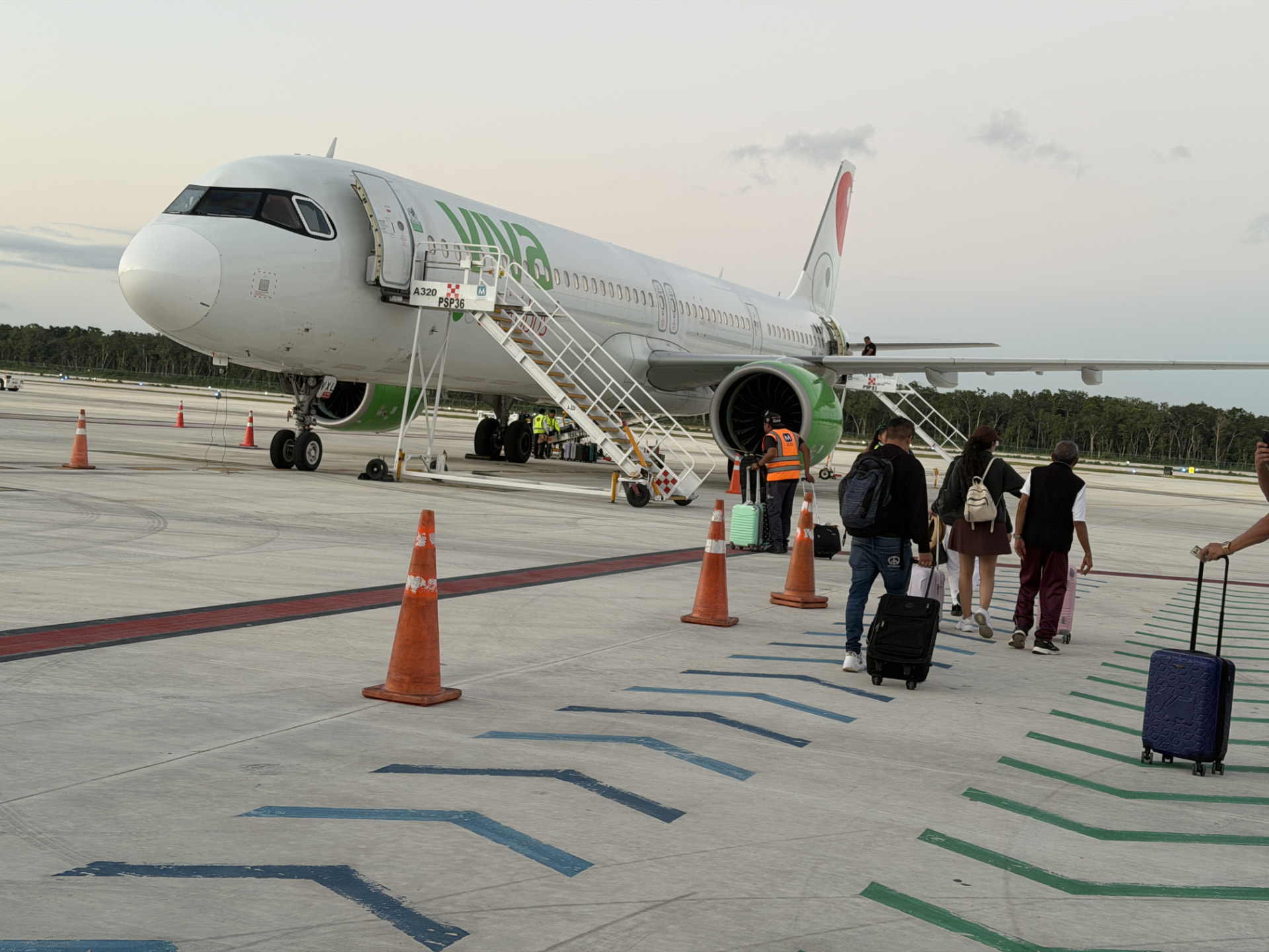 Pasajeros caminando hacia un avión en la pista